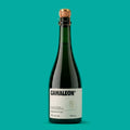 Garrafa de Camaleon, fermentado de cana 750 ml, vidro verde com rolha e gaiola dourada e rótulo creme, em fundo verde